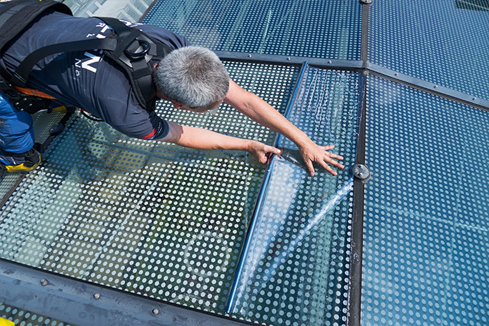 UV-Schutzfolie wird auf Glasdach ausgerollt.